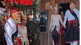Stevi tampak anggun dalam balutan kebaya lembut dan songke bermotif ayam jantan—simbol kesuburan, kekuatan, dan keberanian perempuan Manggarai. Di kepalanya, tersemat mahkota emas khas Manggarai, membuatnya tampak seperti lonto leok, perempuan bangsawan dalam dongeng-dongeng tua.