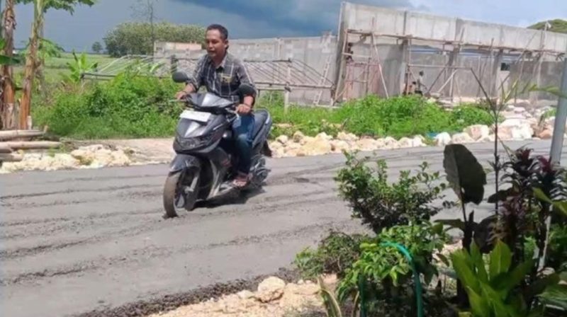 Aksi seorang warga melintasi jalan yang baru saja dicor di Desa Palon, Kecamatan Jepon, Kabupaten Blora, berbuntut proses hukum